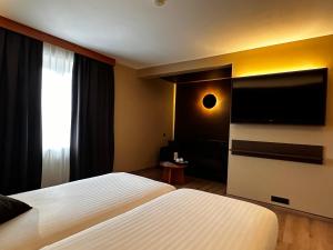 巴斯托涅梅尔巴酒店的酒店客房设有两张床和一台平面电视。