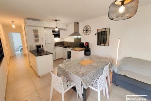 维亚斯Villa T3 climatisée en résidence avec piscine的厨房以及带桌椅的用餐室。