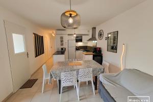 维亚斯Villa T3 climatisée en résidence avec piscine的厨房以及带桌椅的用餐室。