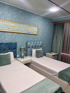 巴库Address Boutique Hotel Baku的蓝色墙壁客房的两张床