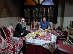 扎古拉Kasbah Of Peace & Boutique的坐在餐桌旁吃饭的男人和女人