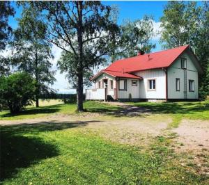 拉平耶尔维Villa Ullakko - vuokramummola, ihana talo maalla的田野上红色屋顶的白色房子