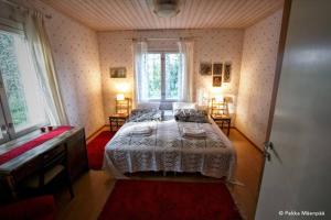 拉平耶尔维Villa Ullakko - vuokramummola, ihana talo maalla的一间卧室配有两张床和一台钢琴