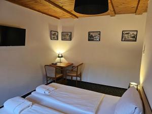 因德日赫城堡比拉帕尼酒店的客房设有一张床、一张桌子和一张桌子。