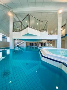 阿克斯莱泰尔姆Résidence Le Grand Tétras- SPA THERMAL INCLUS的一座铺有蓝色瓷砖地板的大型游泳池