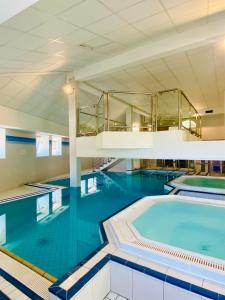 阿克斯莱泰尔姆Résidence Le Grand Tétras- SPA THERMAL INCLUS的大楼内一个蓝色的大型游泳池