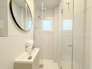 马德里Luminoso, cómodo y buena zona的带淋浴、盥洗盆和镜子的浴室