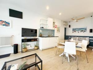 马德里Luminoso, cómodo y buena zona的厨房以及带桌椅的起居室。
