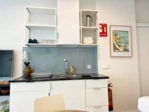 马德里Luminoso, cómodo y buena zona的厨房配有白色橱柜和水槽