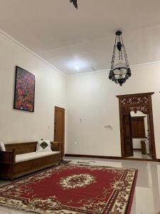 梭罗Omah Pinaringan的一间设有床、地毯和吊灯的客房