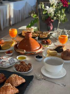 非斯Eventi Club by cité des sports adarissa的一张桌子上放满了食物和茶壶