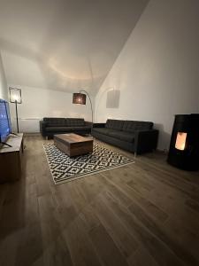 Saint-Georges-sur-BaulcheMaison design de 190m2的客厅配有两张沙发和一张咖啡桌