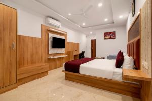班加罗尔Gateway Premium Inn的一间酒店客房,配有一张床和一台电视