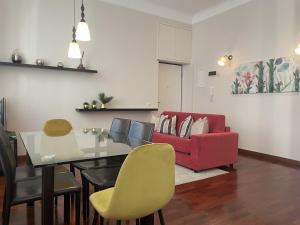 米兰Umbria 60 Apartment的客厅配有餐桌和红色沙发