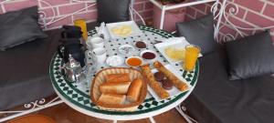 马拉喀什Hotel salem leksor的早餐托盘,包括面包、鸡蛋和床上的饮料