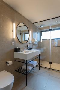 阿姆斯特丹Pestana Amsterdam Riverside的一间带水槽、卫生间和镜子的浴室