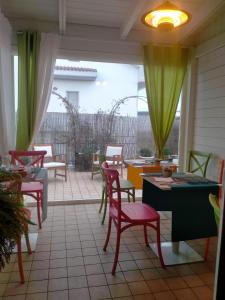 佩斯卡拉SMARTFIT HOUSE - Room & Relax的庭院设有红色的桌椅和绿色的窗帘