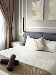 哥打巴鲁Two Bedroom Troika Kota Bharu by AGhome的一间卧室配有带白色床单和枕头的床。