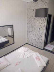 巴西利亚Hotel Canal Hum Pistão的客房设有一张带镜子的白色床和床罩