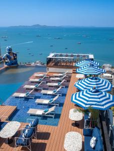 芭堤雅市中心Siam@Siam Design Hotel Pattaya的一排蓝白雨伞和海洋