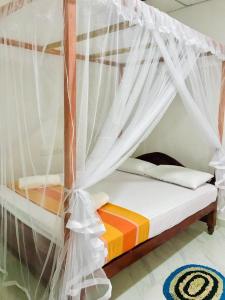 蒂瑟默哈拉默Tashil Hotel & Restaurant的一间卧室配有一张带蚊帐的床