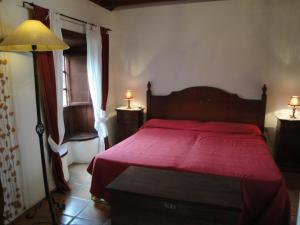 巴列埃尔莫索Casa Rural Guaidil的一间卧室配有一张红色床罩的床