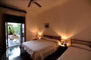 塞尔瓦迪法萨诺Hotel La Silvana的一间带两张床的卧室和一个带桌子的阳台