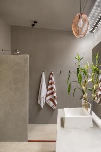 普拉亚德莫伊塔斯Vila Flor Studios的浴室设有白色水槽和镜子