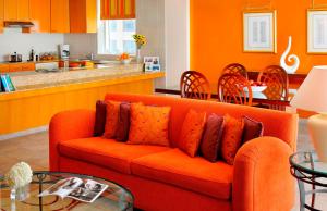 迪拜迪拜克里克万豪行政公寓的一间带橙色沙发的客厅和一间厨房