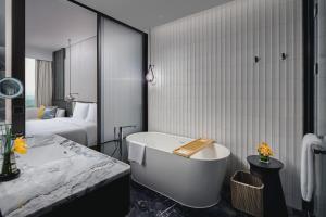鄂州鄂州皇冠假日酒店的带浴缸的浴室和卧室