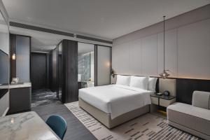 鄂州鄂州皇冠假日酒店的配有一张床和一把椅子的酒店客房