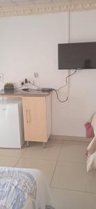 勒迪格Tsoga Odire BNB的一间卧室配有一张桌子,墙上配有电视