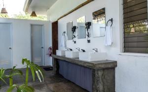 莫阿尔博阿Wild Monkeys Hostel的浴室设有3个水槽和墙上的镜子