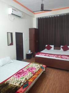 瓦拉纳西Goroomgo Varanasi Paradise Varanasi的酒店客房设有两张床和电视。
