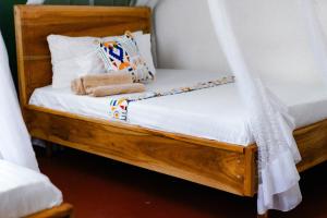 莫希Goodtimewithfar House的一张木床,床上挂着窗帘和枕头