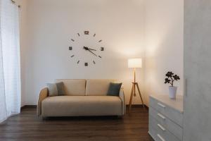 的里雅斯特Residence Piazza Giotti 8的客厅配有沙发和墙上的时钟
