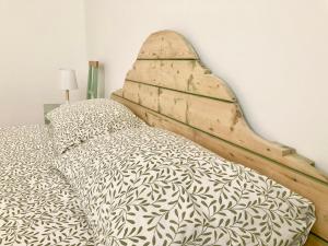 里米尼Anita Bnb Rimini的卧室内的一张带木制床头板的床
