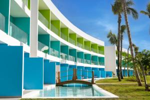 蓬塔卡纳Sunrise Miches Beach Resort, Punta Cana - All Inclusive - Adults Only的一座带游泳池和棕榈树的建筑