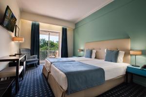 维塞乌格劳瓦斯科酒店的配有一张床、一张书桌和一扇窗户的酒店客房
