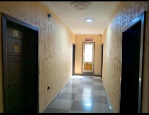 拉各斯Hibis k hotel (green gate)的一条空的走廊,有门,铺着瓷砖地板