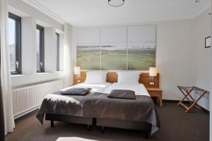 UithuizermeedenHunzego Hotel的一间卧室配有一张大床和两个枕头