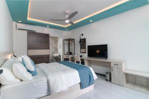乌库拉斯Ukulhas Sands的一间卧室配有一张床、一张书桌和一台电视