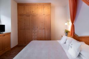 费拉迪普利米罗Hotel Castel Pietra的一间带大床和电视的卧室