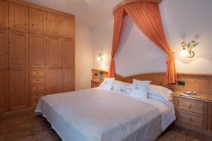费拉迪普利米罗Hotel Castel Pietra的一间卧室配有一张带橙色窗帘的大床