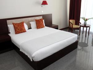 BenguelaFlow Hotel Benguela的卧室配有带红色枕头的大型白色床