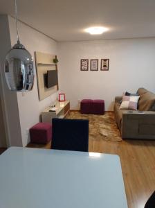 新彼得罗波利斯Apartamento Cantinho do Aconchego-Nova Petrópolis的客厅配有沙发和桌子
