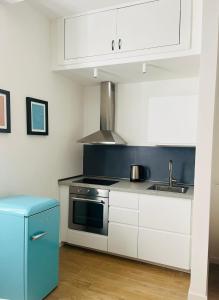 米兰Lomat Apartment的厨房配有白色橱柜、炉灶和水槽。