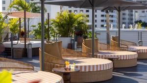 迈阿密海滩Uma House by Yurbban South Beach的屋顶上带桌子和遮阳伞的庭院