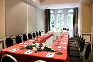 洛桑洛桑卡尔顿精品酒店的红色桌布的房间的一排桌子