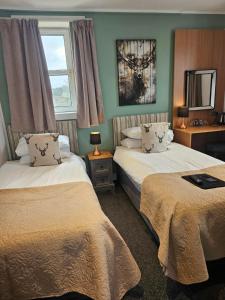 托伯莫里公园旅舍酒店的酒店客房设有两张床和窗户。